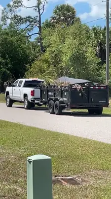 Dump trailer loaded with brush and tarped, ready to haul