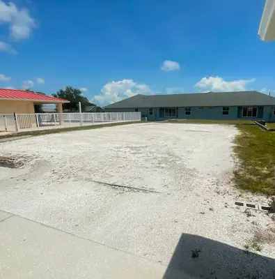 Worn, patchy parking area before new gravel