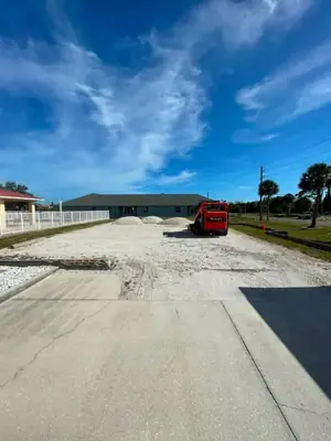 Gravel being delivered and spread on a parking area