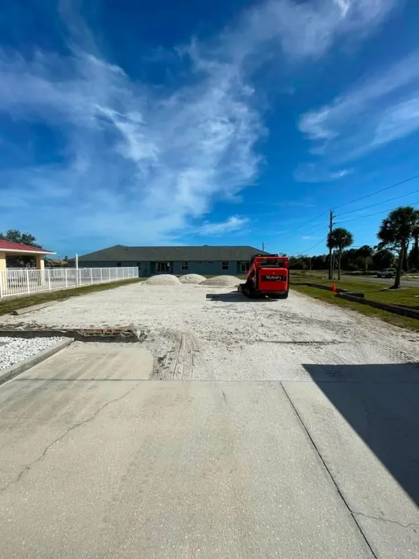 Gravel being delivered and spread on a parking area