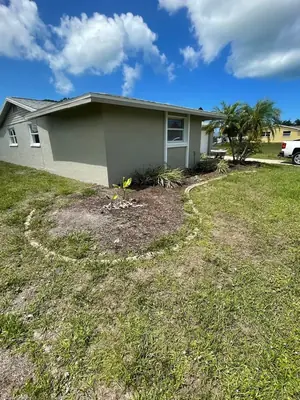 Bare outlined bed beside a home before mulch