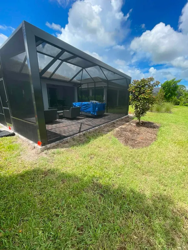 Grass beside a pool cage before a new bed